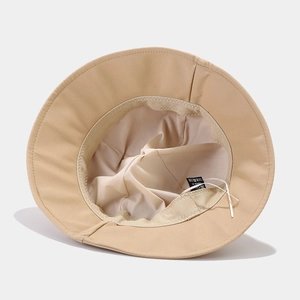 Close-up of the beige sun hat interior showing sweatband and fine stitching details