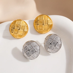 Detailansicht der 18K Gold- und Silber-Ohrstecker mit Gitterstruktur auf einem Teller