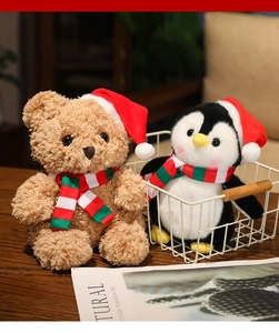 Dettaglio di morbidi peluche natalizi con orsetto, pinguino e sciarpe a righe festive