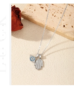 Detail view of silver Hamsa Hand and Evil Eye pendant necklace with sparkling zircons