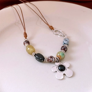 Macro view of vintage beaded flower necklace with silver pendant and colorful stone beads