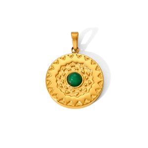 Macro view of a gold-plated stainless steel round pendant with a green gemstone inlay