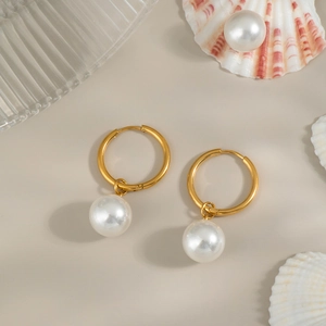 Primer plano detallado de pendientes vintage franceses de oro de 18K con perlas blancas