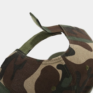 Detail view of the adjustable green velcro strap on a woodland camo baseball cap
