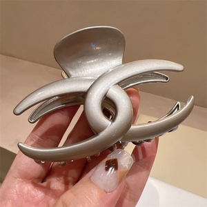 Detail shot of a large Y2K metallic silver claw clip with a sleek pearlescent finish