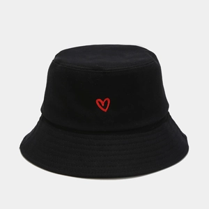 Detail of red heart embroidery on the front of a black cotton bucket sun hat for unisex