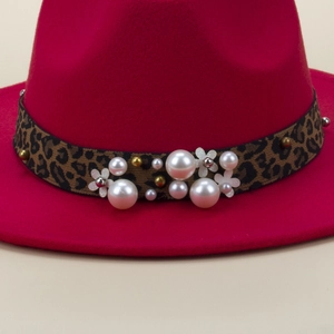 Vue détaillée du chapeau en laine rose avec ruban léopard, perles et décor de fleur