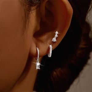 Detail of 925 sterling silver earring set with zircons and pearls on a female model