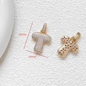 Macro detail of cubic zirconia cross pendant showing 29x20mm dimensions and golden back