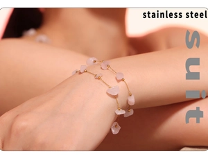 Detail of gold stainless steel bracelet with irregular pink natural stone on model