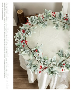 Detail showing artificial red berries and flocked green leaves on Christmas garland decor