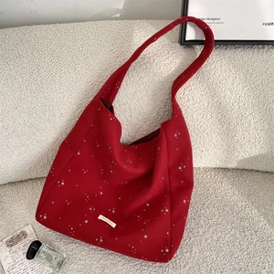 Dettaglio della borsa hobo in lana rossa con stelle d'argento su sfondo pile