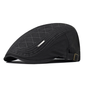 Detail of black cotton flat cap featuring diamond quilting and adjustable metal buckle strap