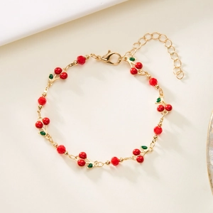 Detail of cherry bracelet with red faceted beads and adjustable gold lobster clasp