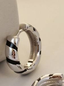 Macro detail of S925 sterling silver earring featuring black striped enamel texture
