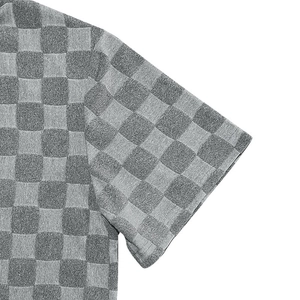 Detail of grey checkerboard jacquard texture on short-sleeve polo shirt sleeve