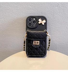 Detail of black quilted pouch with pink butterfly and gold twist lock on iPhone case