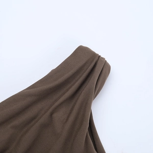 Detailed view of dark brown knitted fabric showing elegant draped pleats and texture
