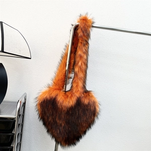 Detail of heart-shaped faux raccoon fur shell bag with orange gradient and long handle