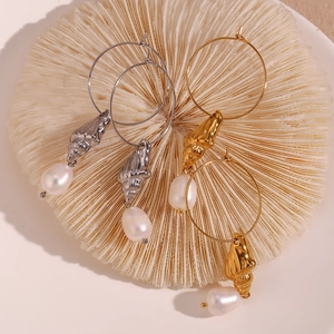 Detail of 18K gold and silver hoop earrings with seashell charms and freshwater pearls