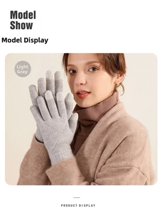 Close-up of light gray winter knitted gloves with touch screen fingertips and cable texture