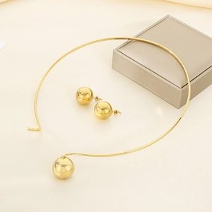 Polished gold stainless steel choker and stud earrings set on a minimalist beige base