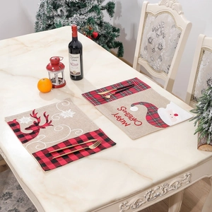 Close-up of beige linen placemats with Santa Claus and reindeer embroidery for Christmas