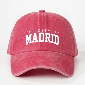 Detailed macro view of the vintage washed red cotton fabric on Madrid baseball cap