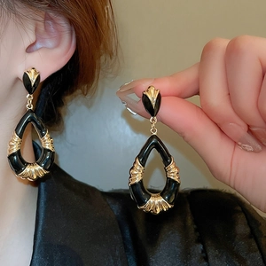 Macro shot of vintage black enamel drop earrings with gold-plated hollow waterdrop design