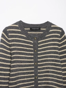 Detail of striped knit cardigan featuring golden metal buttons and soft fabric texture