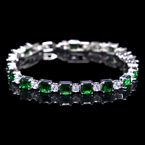 Detail of silver tennis bracelet with green square and clear round zirconia stones