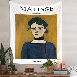 Detail of Matisse portrait tapestry hanging above a wooden cabinet with cozy decor