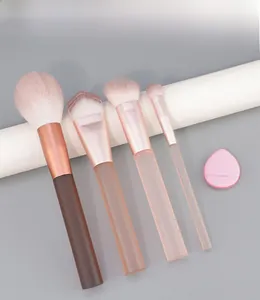 Detail of 4-piece makeup brush set with pink sponges on a clean white display stand