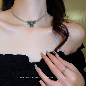 Silver choker necklace with green crystal butterfly pendant and matching ring on model