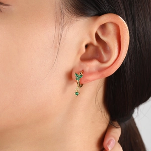 Gold plated hoop earrings with green butterfly zircon cluster shown on model