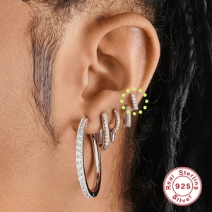 Close-up of 925 sterling silver cartilage studs and hoops with zircon on model ear