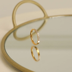 Detailed macro view of 18k rose gold ring with CNC micro-paved diamonds on mirror