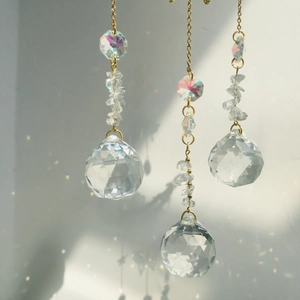 Macro shot of large faceted crystal balls reflecting rainbow light spots on wall