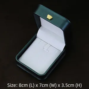 Detail view of dark green jewelry gift box with gold crown logo and white interior lining