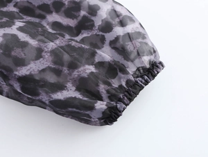 Detail of leopard print organza dress showing elastic cuff and sheer fabric texture