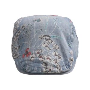 Detailed view of floral embroidery on light blue washed denim beret cap
