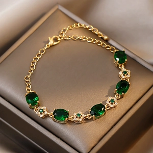 Détail du bracelet fleuri en or et émeraude avec des pierres de zircon scintillantes