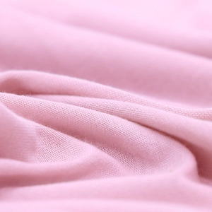 Close-up of soft pink jersey knit fabric showing high-quality texture and weave structure