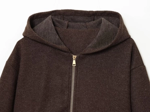Detail view of deep brown hooded jacket with metal zipper and soft fleece texture