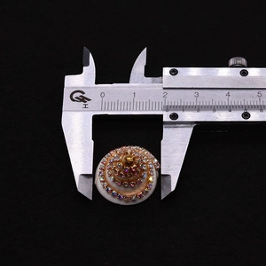 Macro-opname van schelpvormige strass hanger gemeten met een schuifmaat