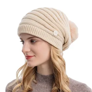Bonnet d'hiver en grosse maille beige avec boutons latéraux et pompon en fausse fourrure