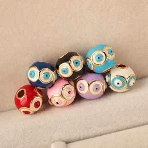 Colorful Evil Eye beads in various enamel finishes displayed on beige velvet background