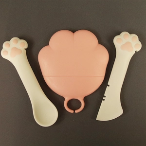 Pink cat paw silicone lid and cream spoon set for pet food cans on dark background