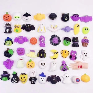 Flat lay of diverse Halloween resin charms like pumpkins, ghosts, and bats on white background