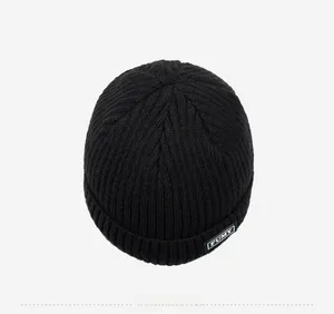 Detailed top view of a black ribbed knit beanie featuring a stitched FUMY logo label